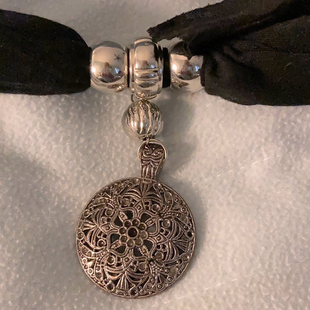 Black scarf with attached jewelry.